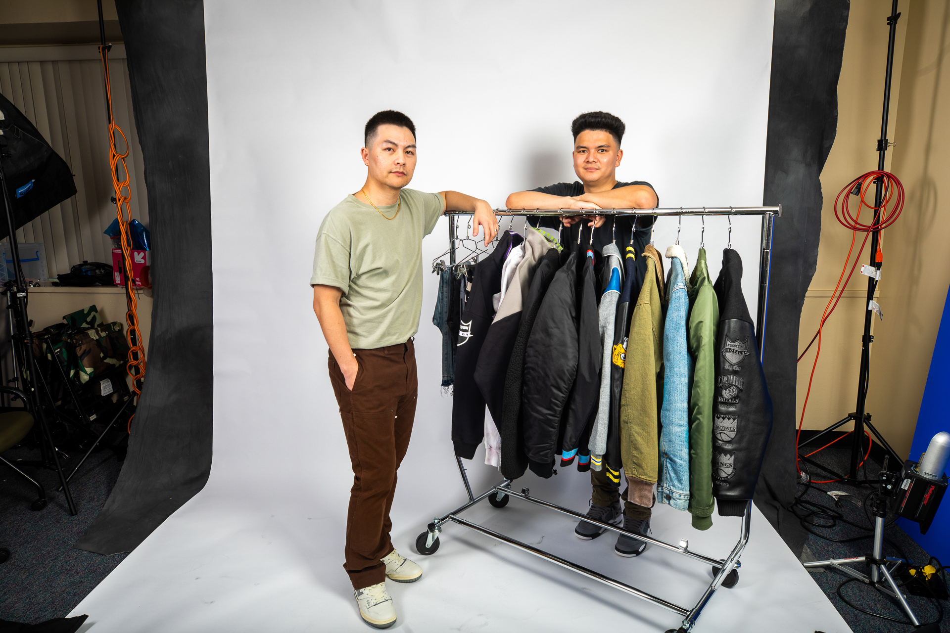 Jason Vu (left), creator of men's clothing line AUTHMADE, poses with a clothing rack full of NBA-themed fashion apparel items created as part of his brand.