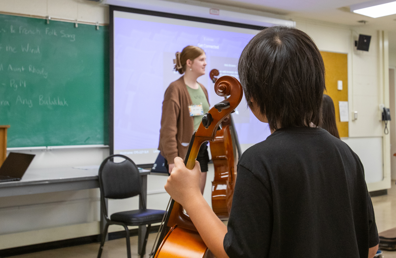 A Sac State students instructs a class of K-12 students in music.