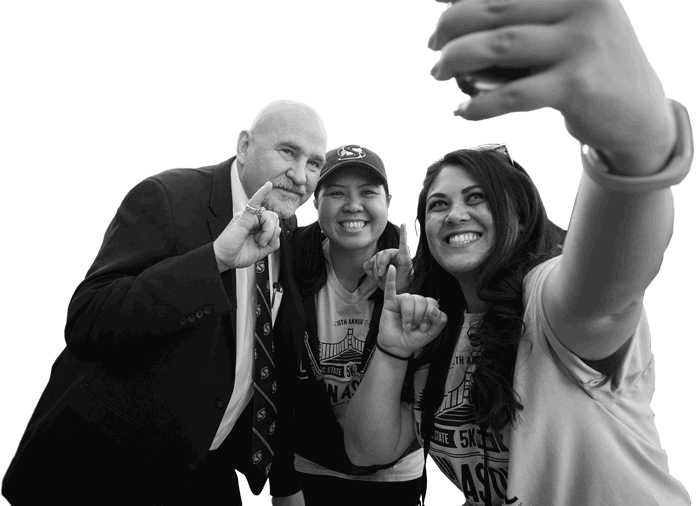 Headshot of Sac State university president Robert Nelson with two students