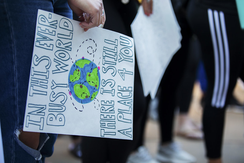 Hand of student holding sign with text and picture of globe
