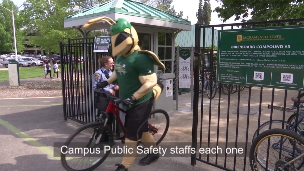Herky rides a bike out of a bike compound.