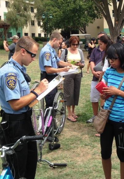 A community service officer helps a female student register her bike