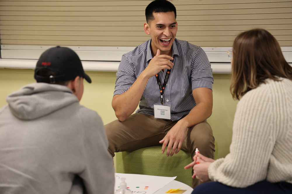 Male student laughing with two team members