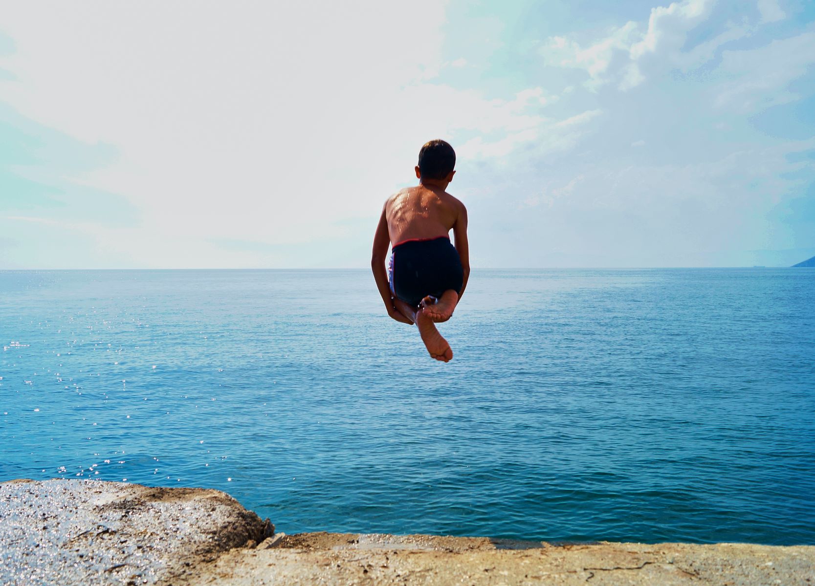 Boy diving into ocean