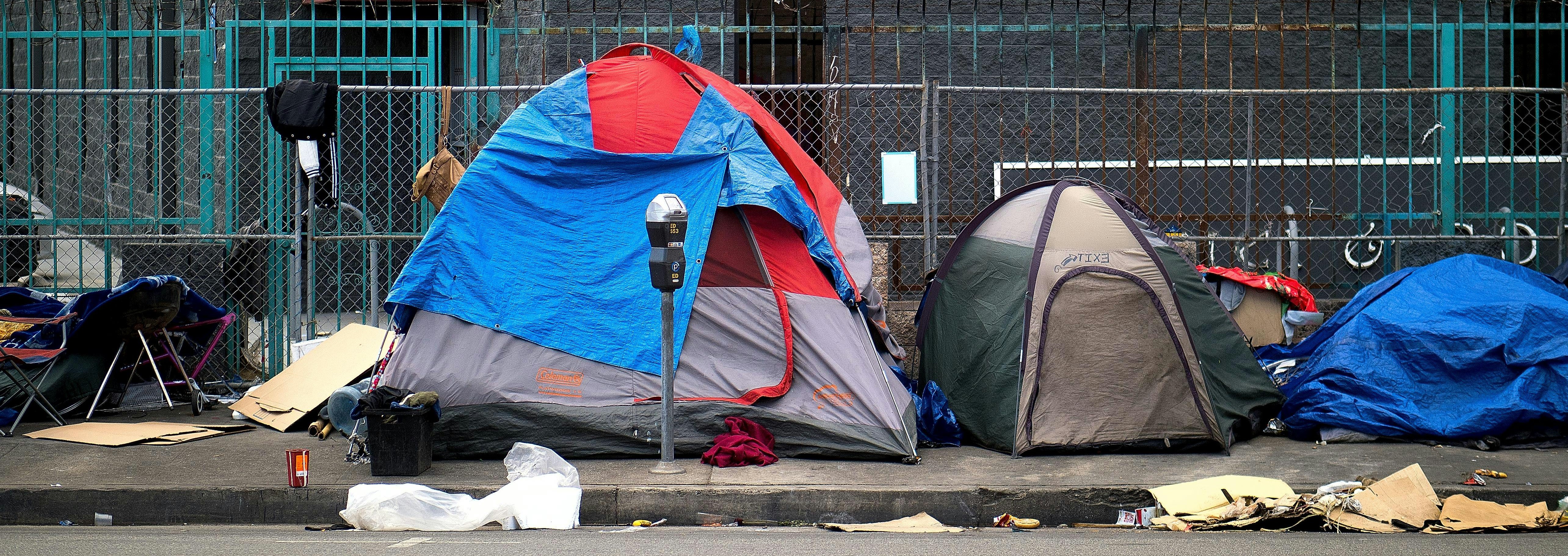 Tents of a homeless encampment on a city sidewalk