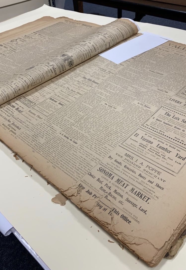 Image of historic newspaper out of storage to be digitized and preserved.