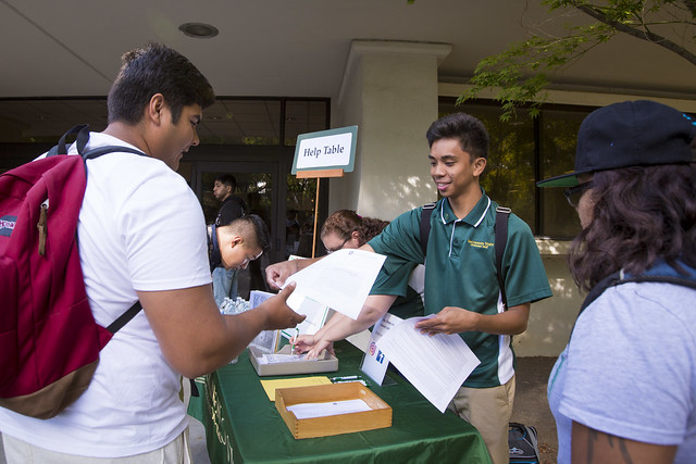 Orientation help table with students distributing orientation matterial