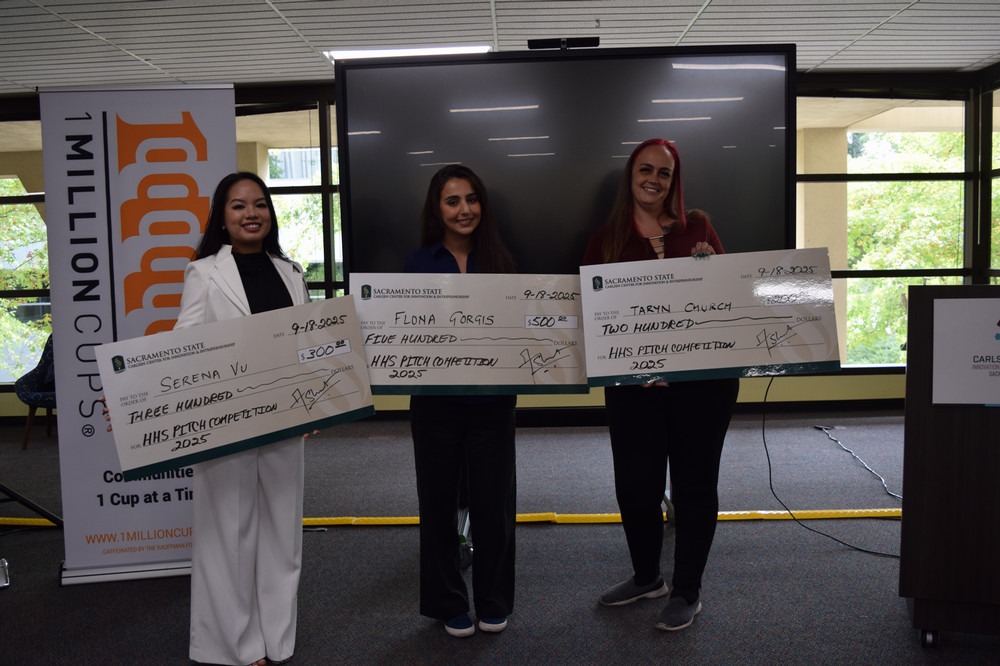 Three winners together holding large checks.