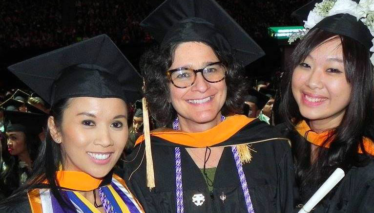 Two female graduates of the Sac Nursing Program smile with professor