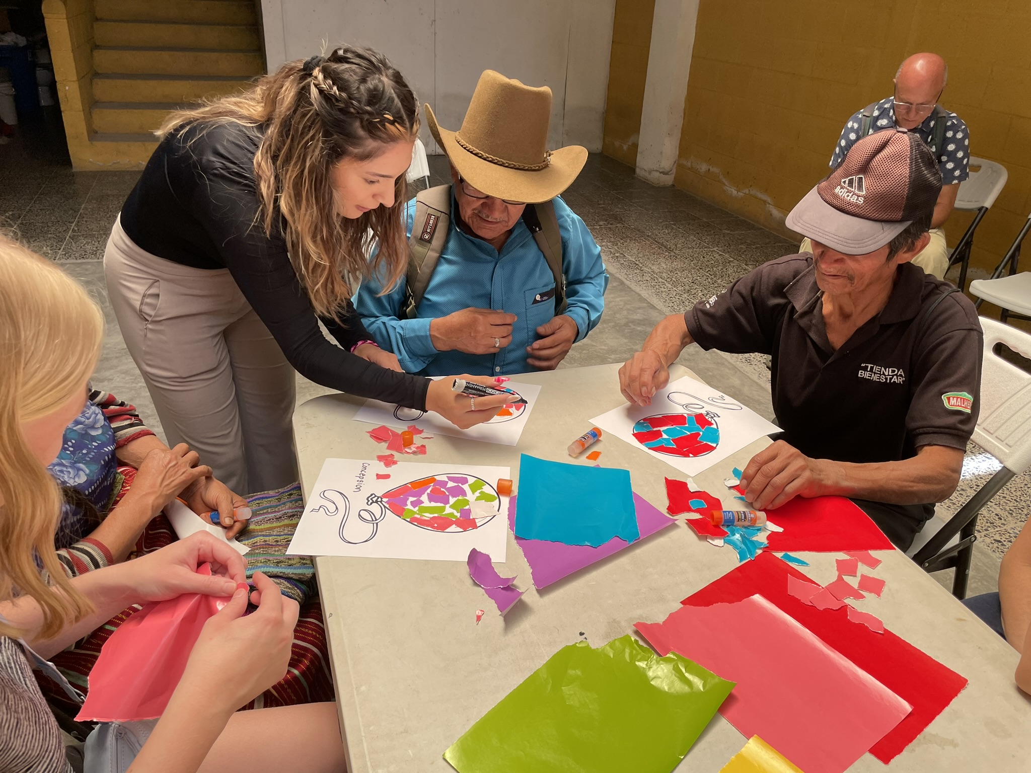 Study Aboard student and two seniors are creating a craft paper.