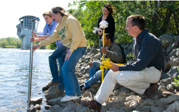 group of people sitting near a lake