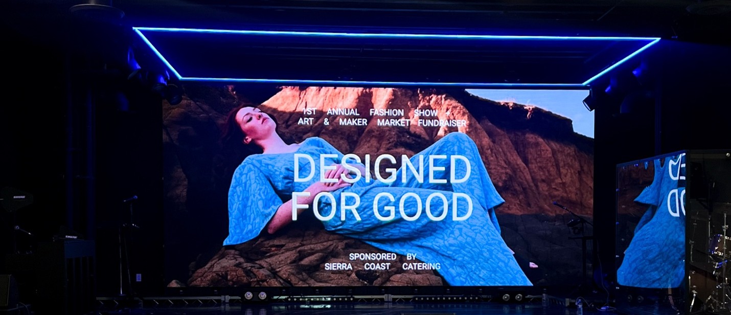 a stage with a background of a woman posing on a rock with the words"Design for Good" at the bottom of the image