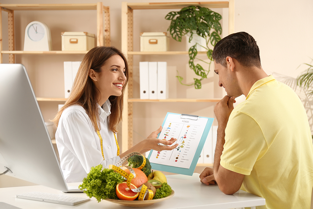 Dietician meets with a male client to go over meal planning