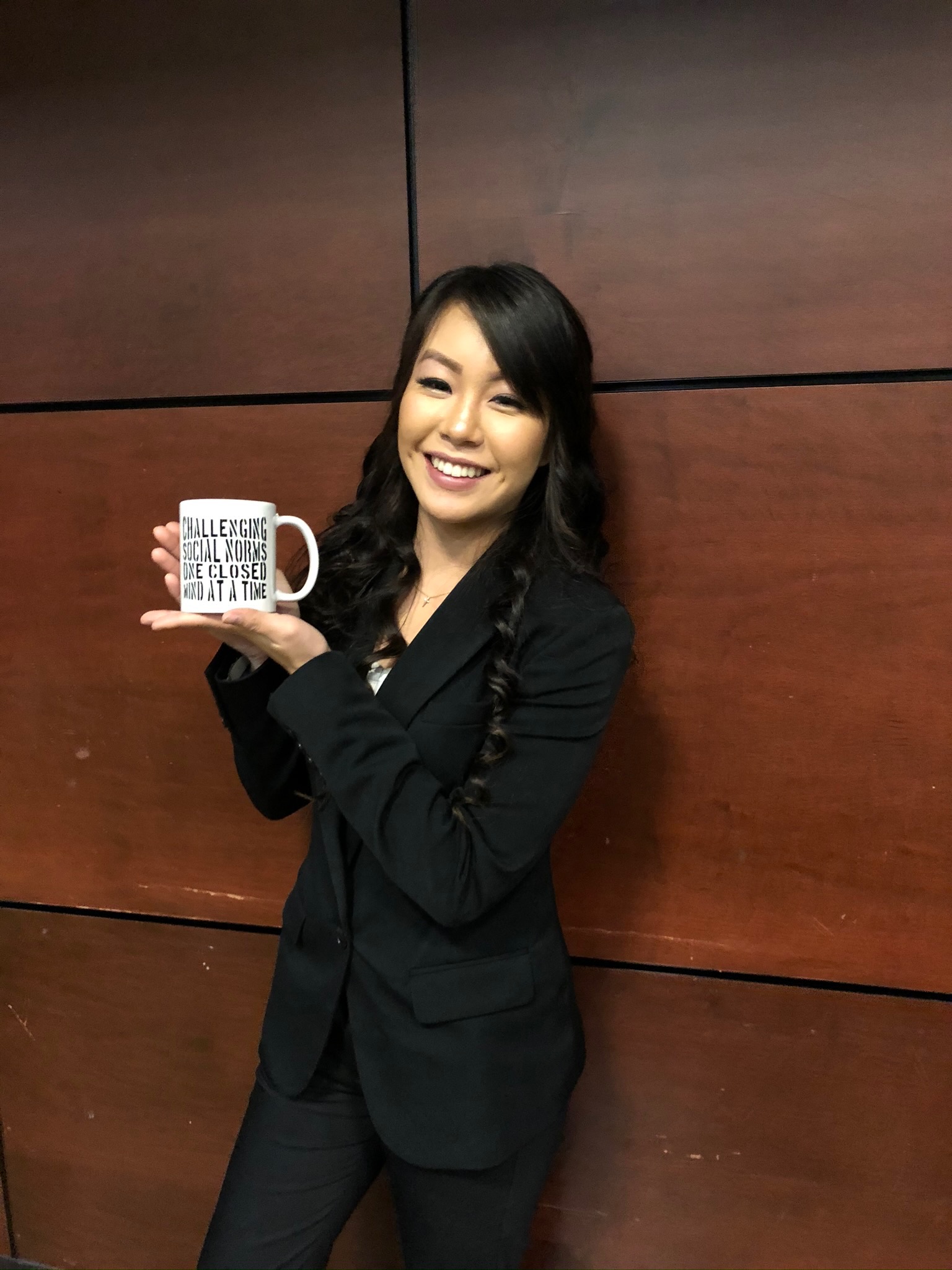 A student holding a coffee mug that they won in a raffle.