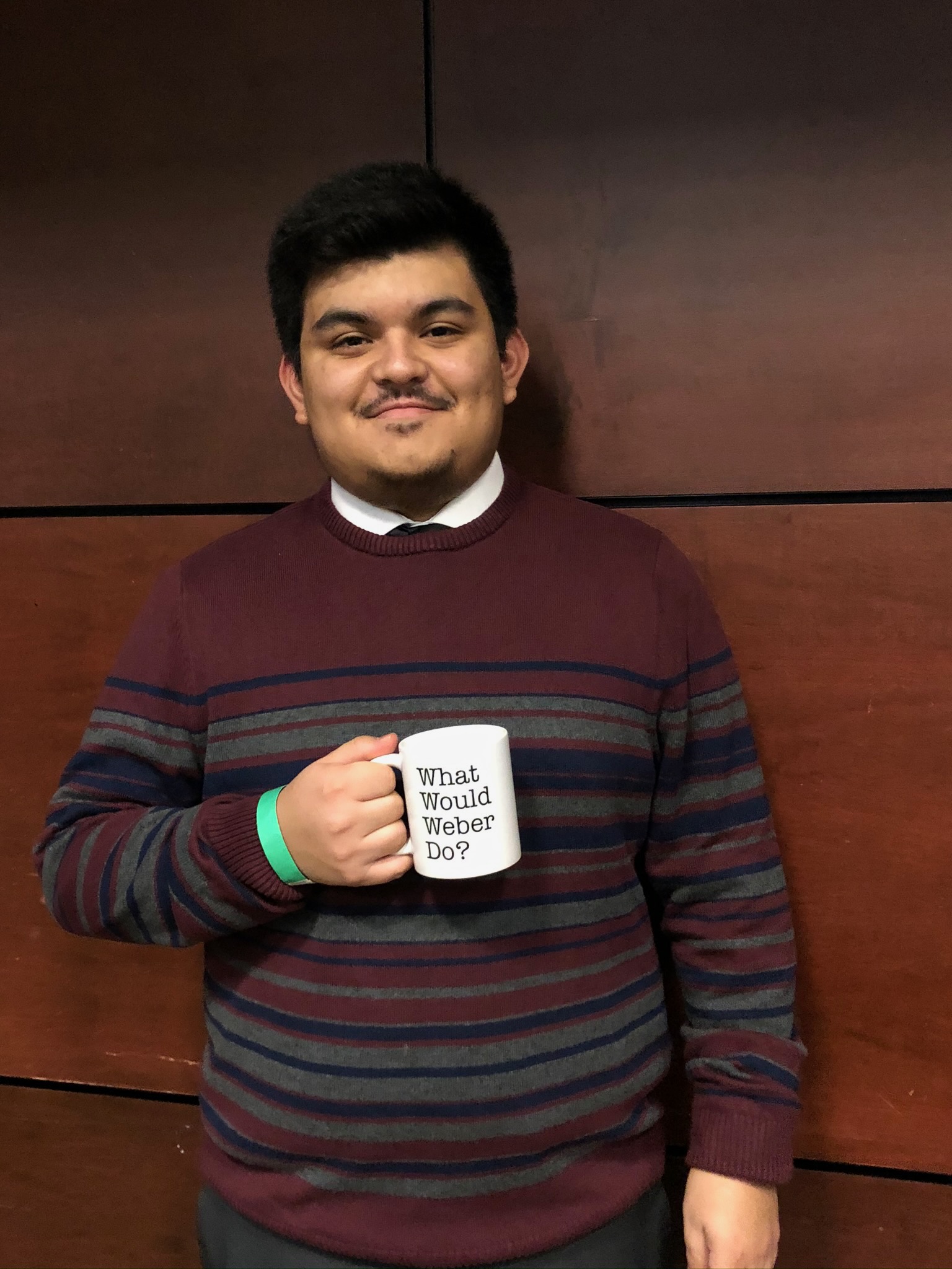 A student holding a mug that they won in a raffle.