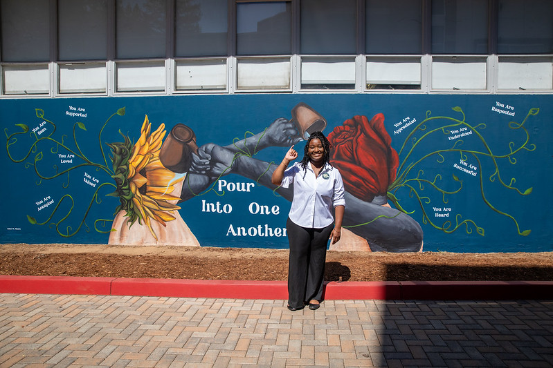 Amari Moore in front of her mural