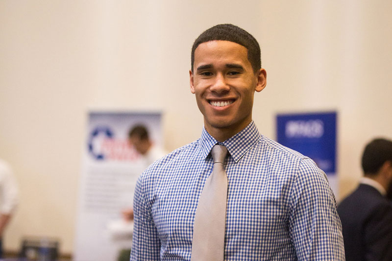 Smiling staffer in a pink tie