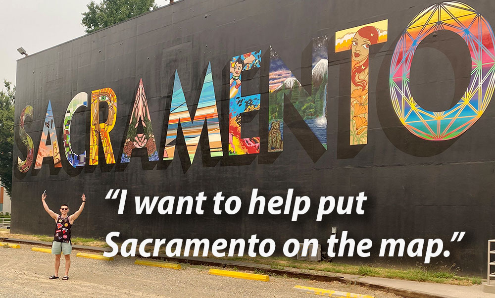 John stands arms outstretched before the Sacramento mural on campus. A quote reads, "I want to put Sacramento on the map."