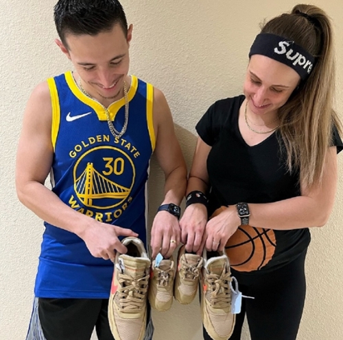 John and his wife hold up their shoes along with a pair for their baby.