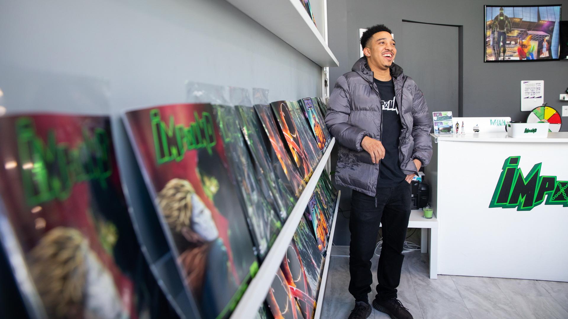 Brent Trayce Sands leans against a shelf of comic books in his Impound Comics DOCO store.