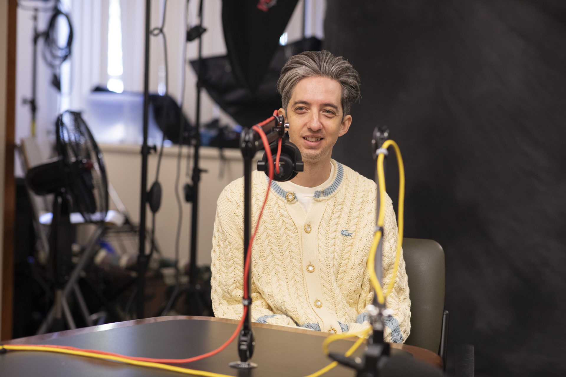 Cole Cuchna sitting at a desk behind a microphone.