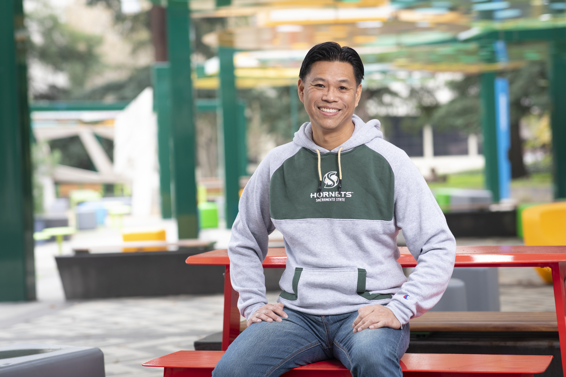 Alumnus Baldwin Chiu sports his Sac State gear and a huge smile on campus.