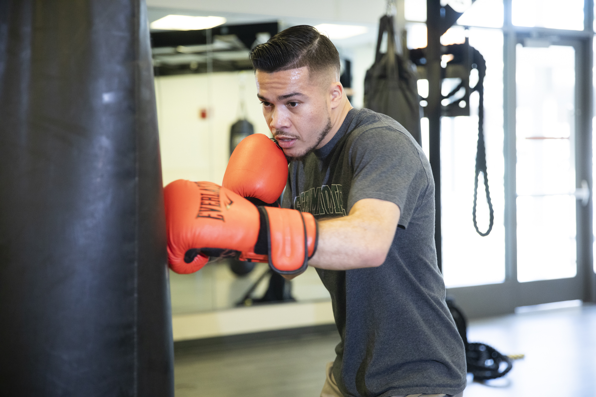 Sac State alumnus and boxer Kevin Montano works out with a punching bag.
