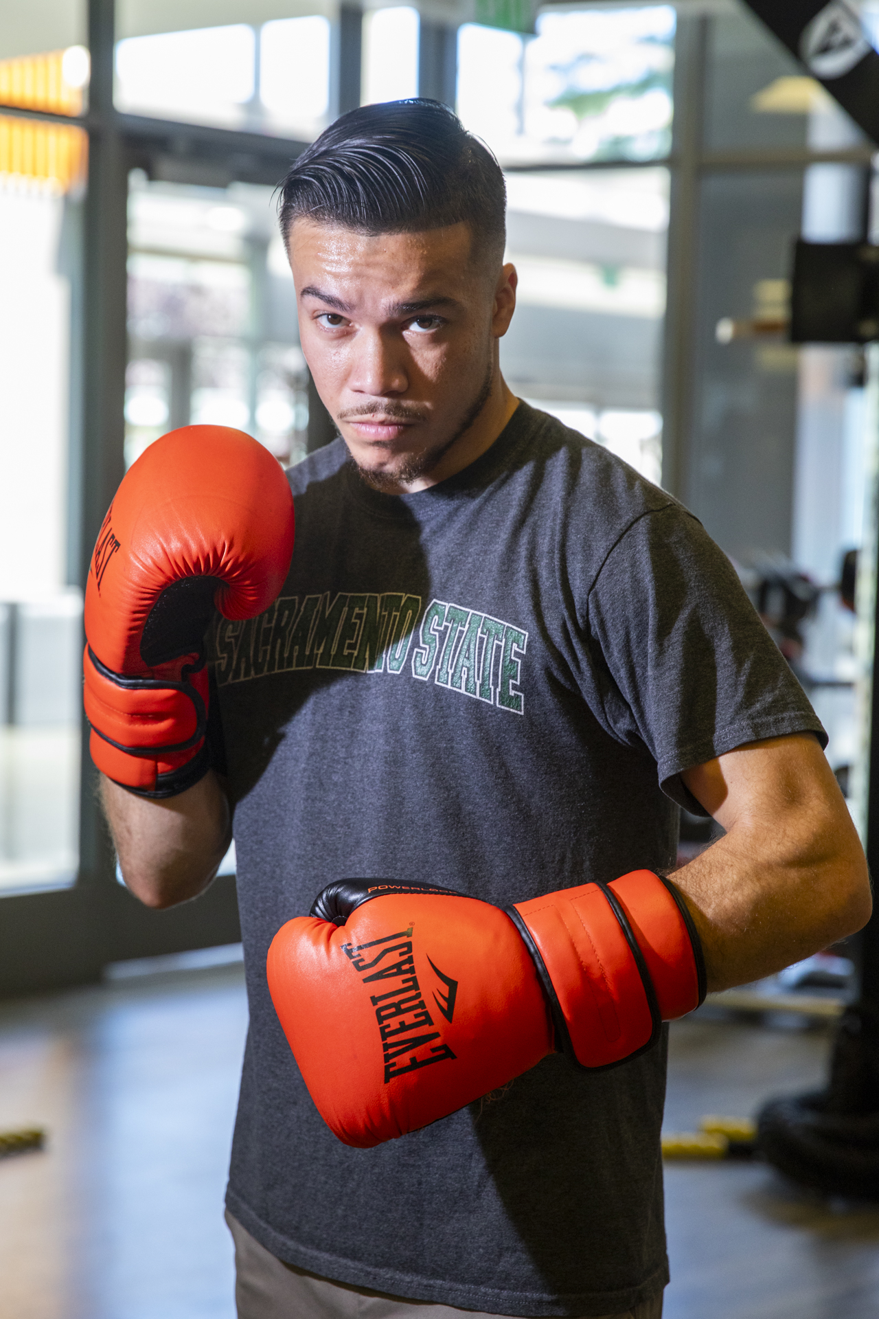 Kevin Montaño poses in The WELL with boxing gloves on.