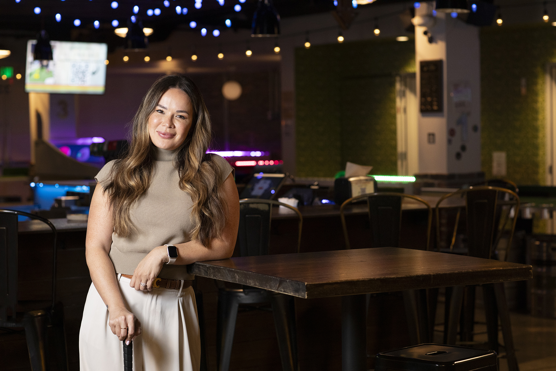 Jennifer Robinson poses inside a Tipsy Putt location in Sacramento's Downtown Commons. 