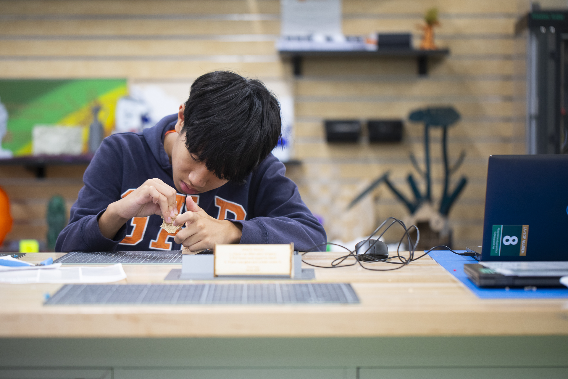 A young student works at a table inside the StingerStudio Makerspace.