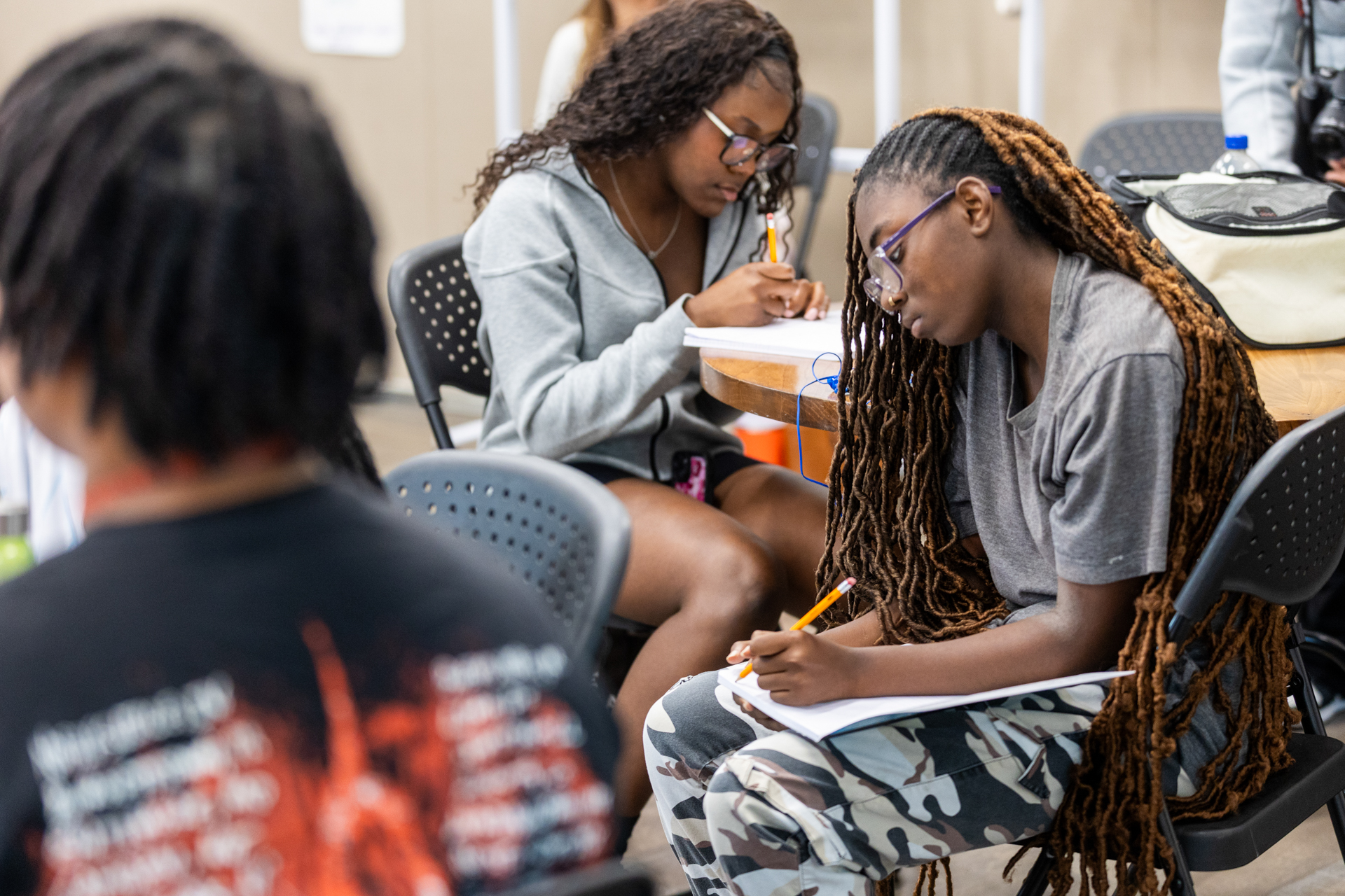Students at tables write in their journals.
