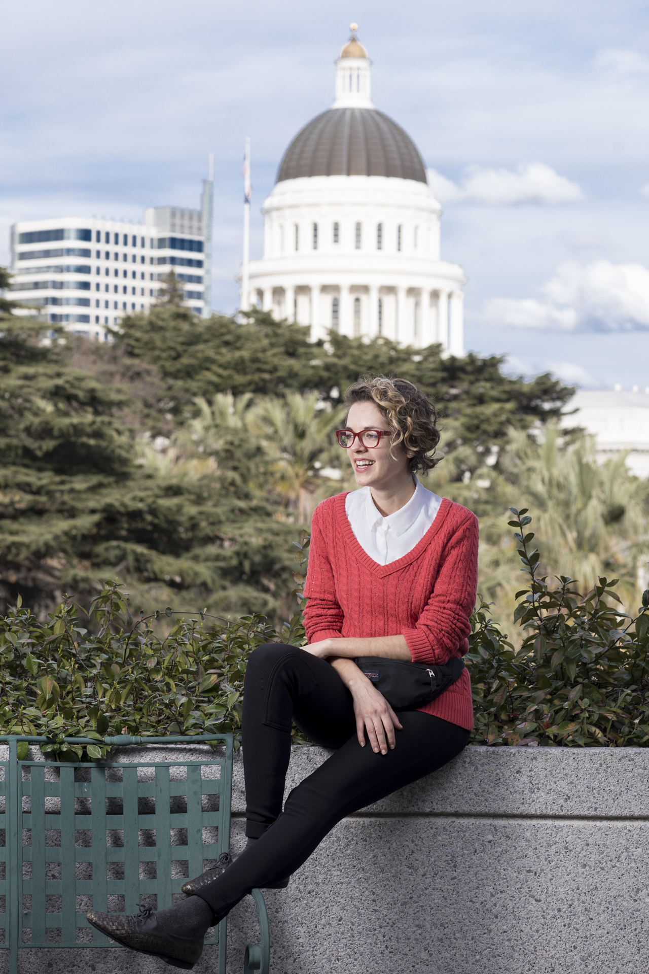 Shahera Hyatt sitting outdoors, with a view of the California state Capitol in the background.