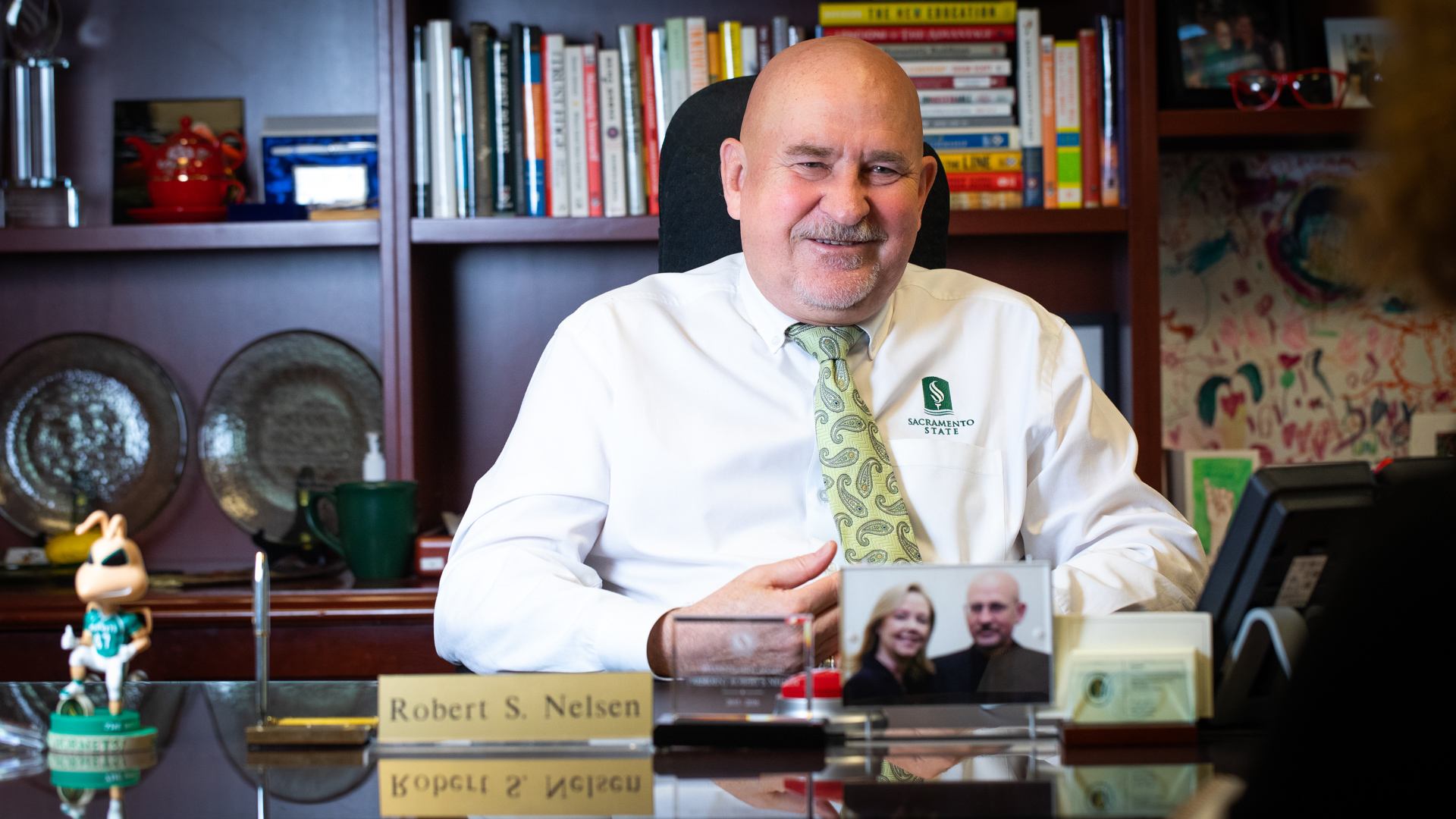 President Robert S. Nelsen sitting at his desk and smiling.