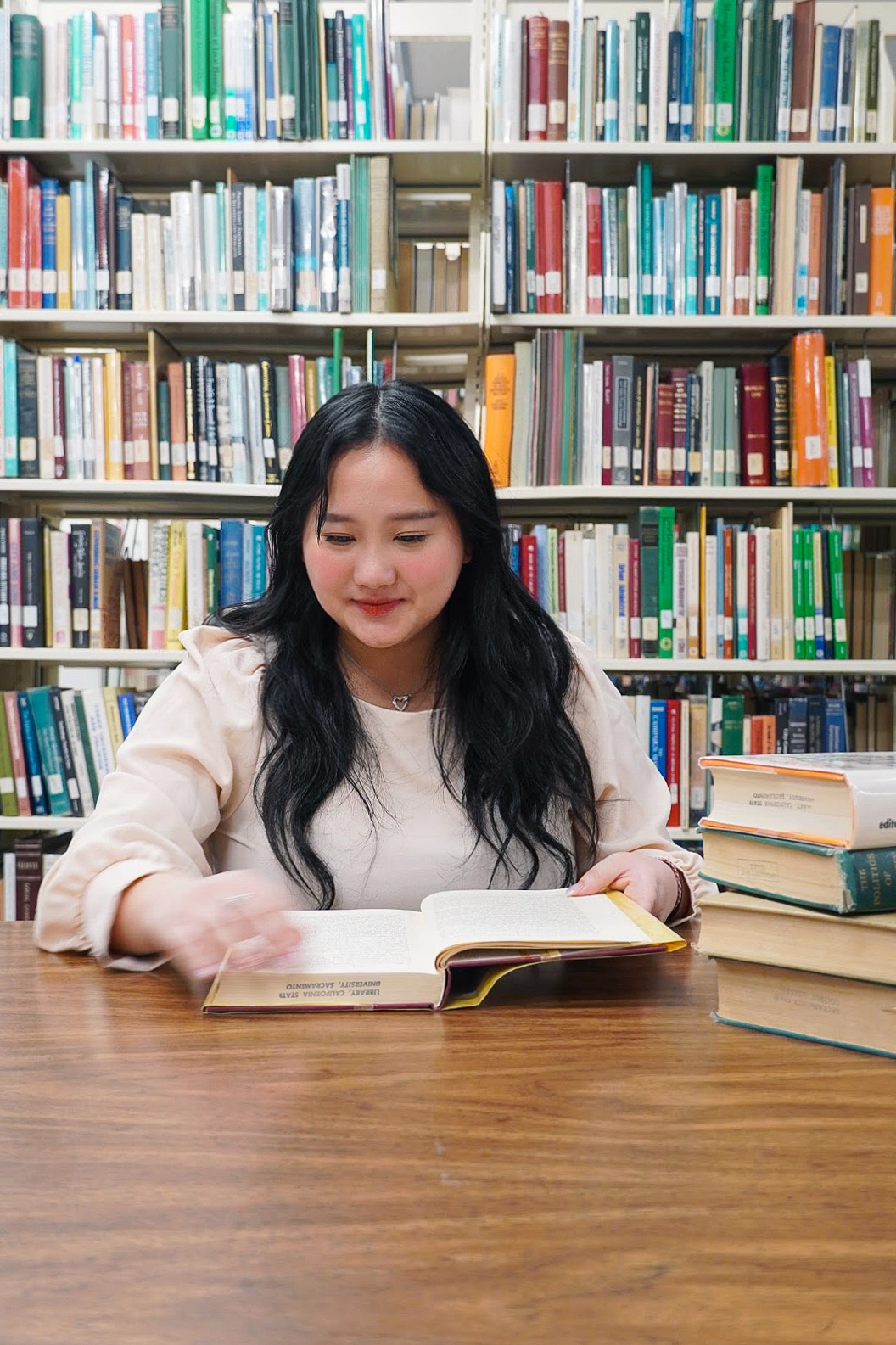 Yee Thao, reading in a library