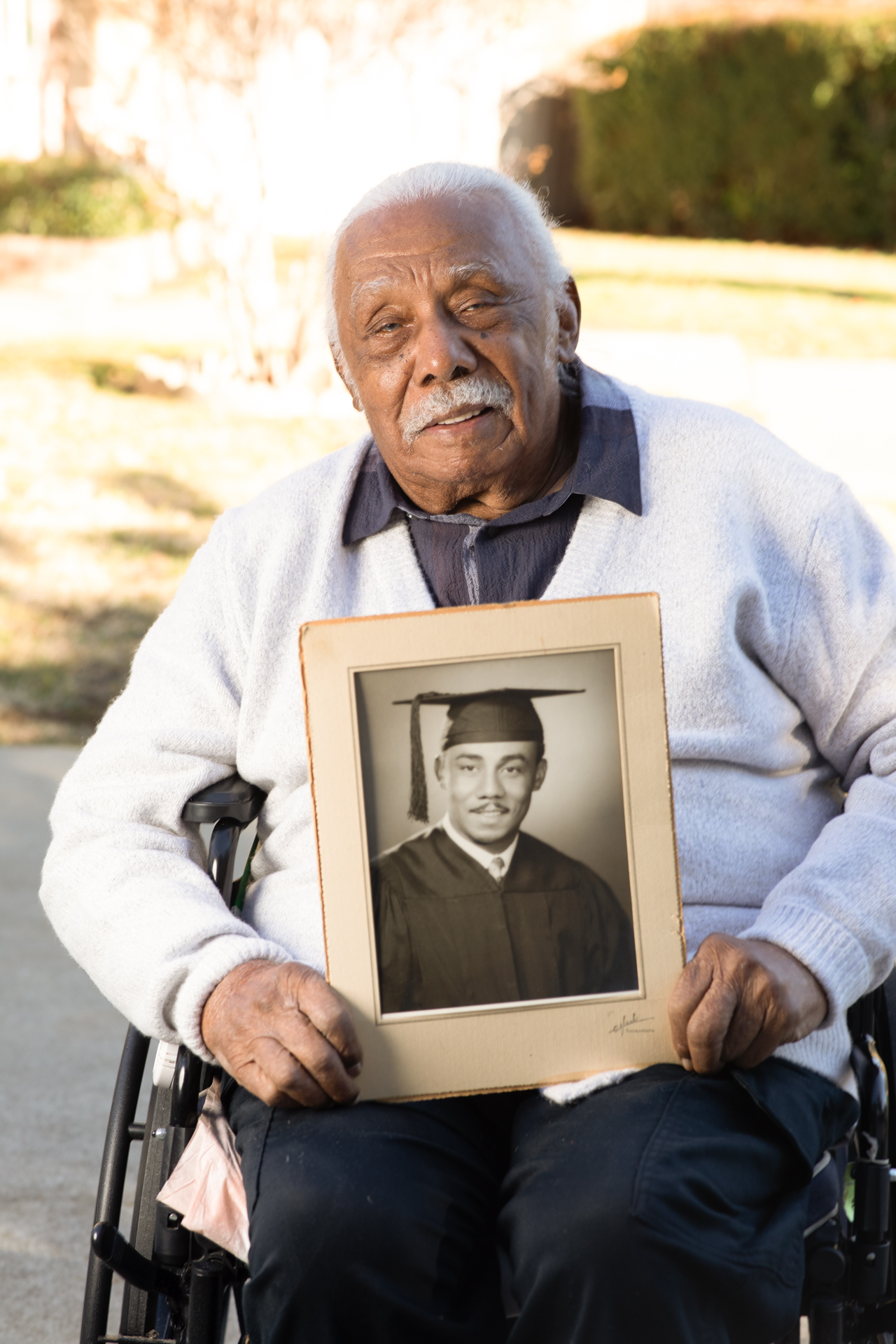 Anthony Francis holds a photo of himself from his graduation. 