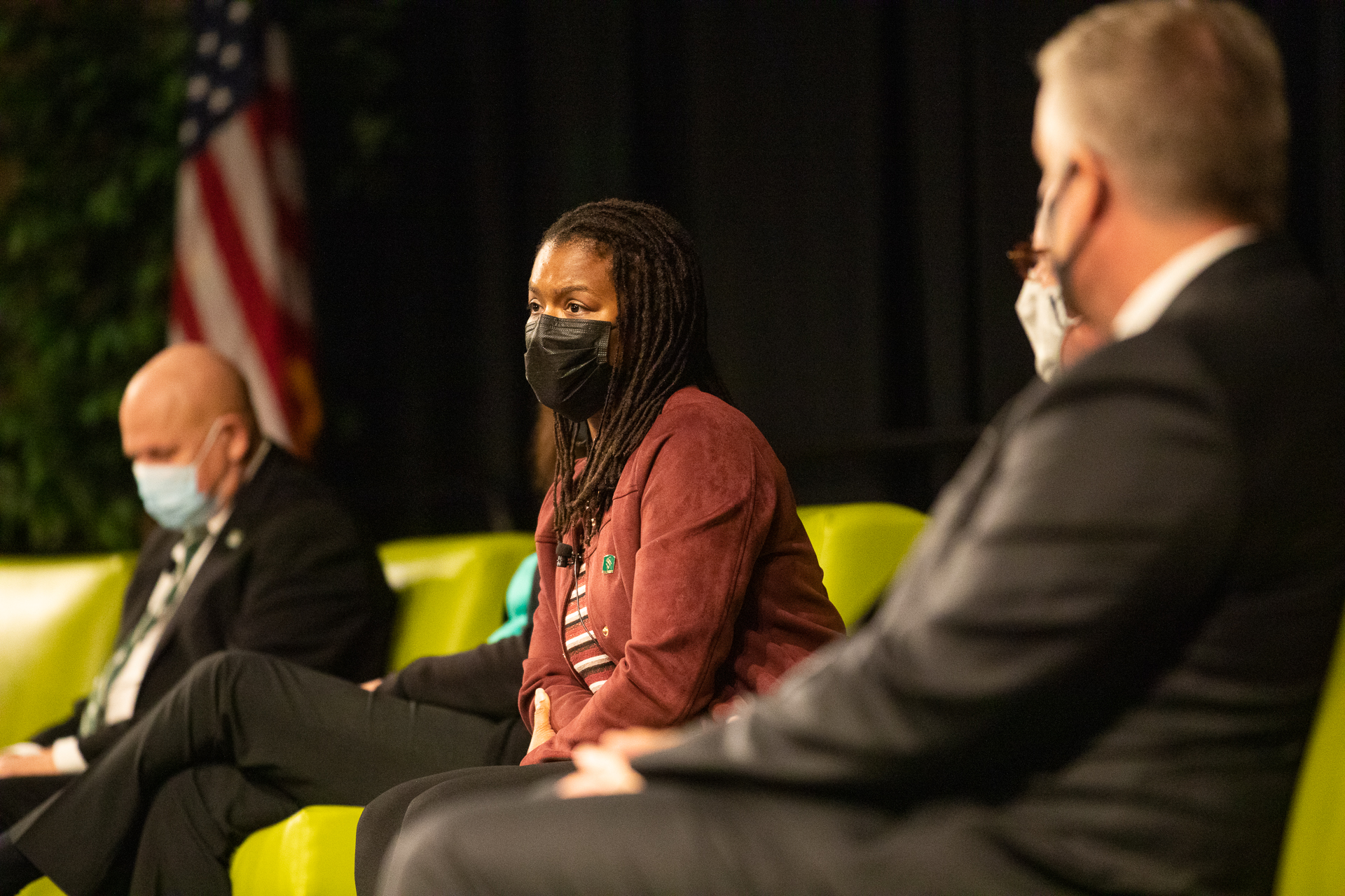 Melinda Wilson Ramey, on stage, wearing a face covering, listens to a question from the audience following the President's Fall Address.