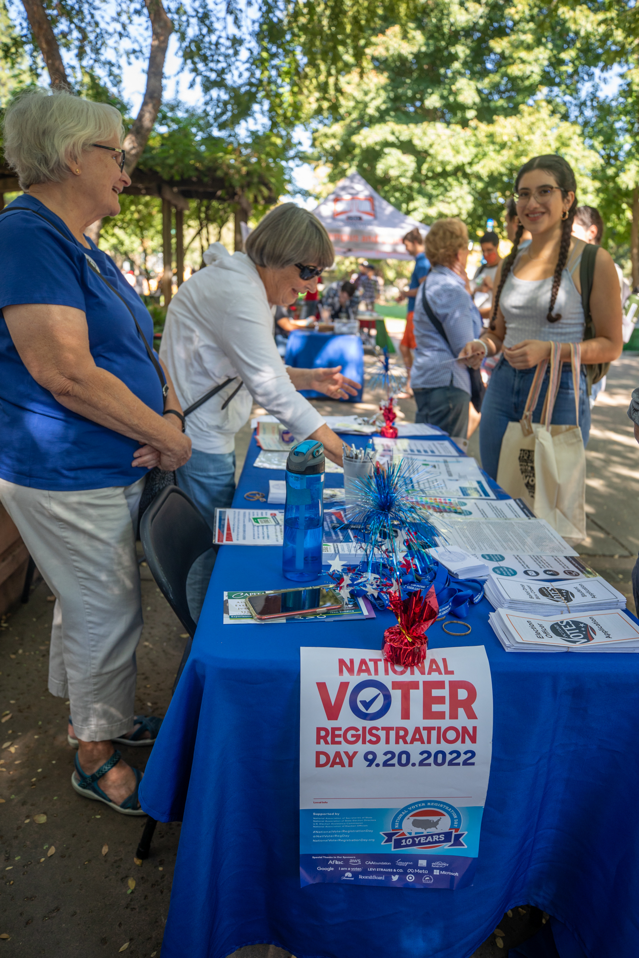 A student visits a voter registration table, all decked out in red, white and blue, during the sixth annual Civic Engagement Resource Fair at Sac State.