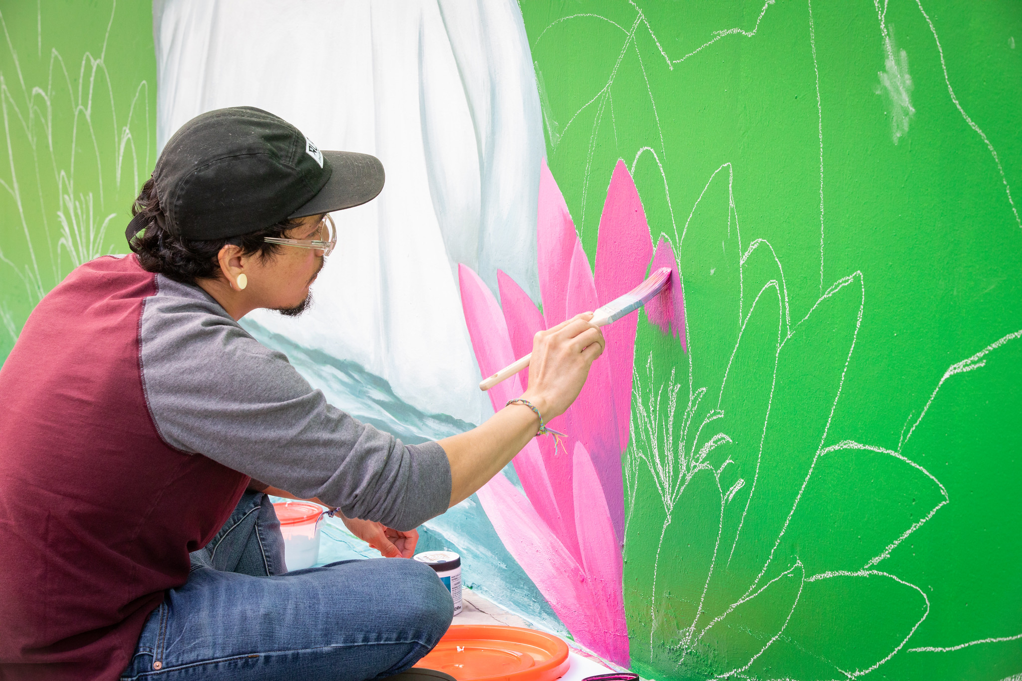 Erik Oliver painting a mural on the outside of Santa Clara Hall.