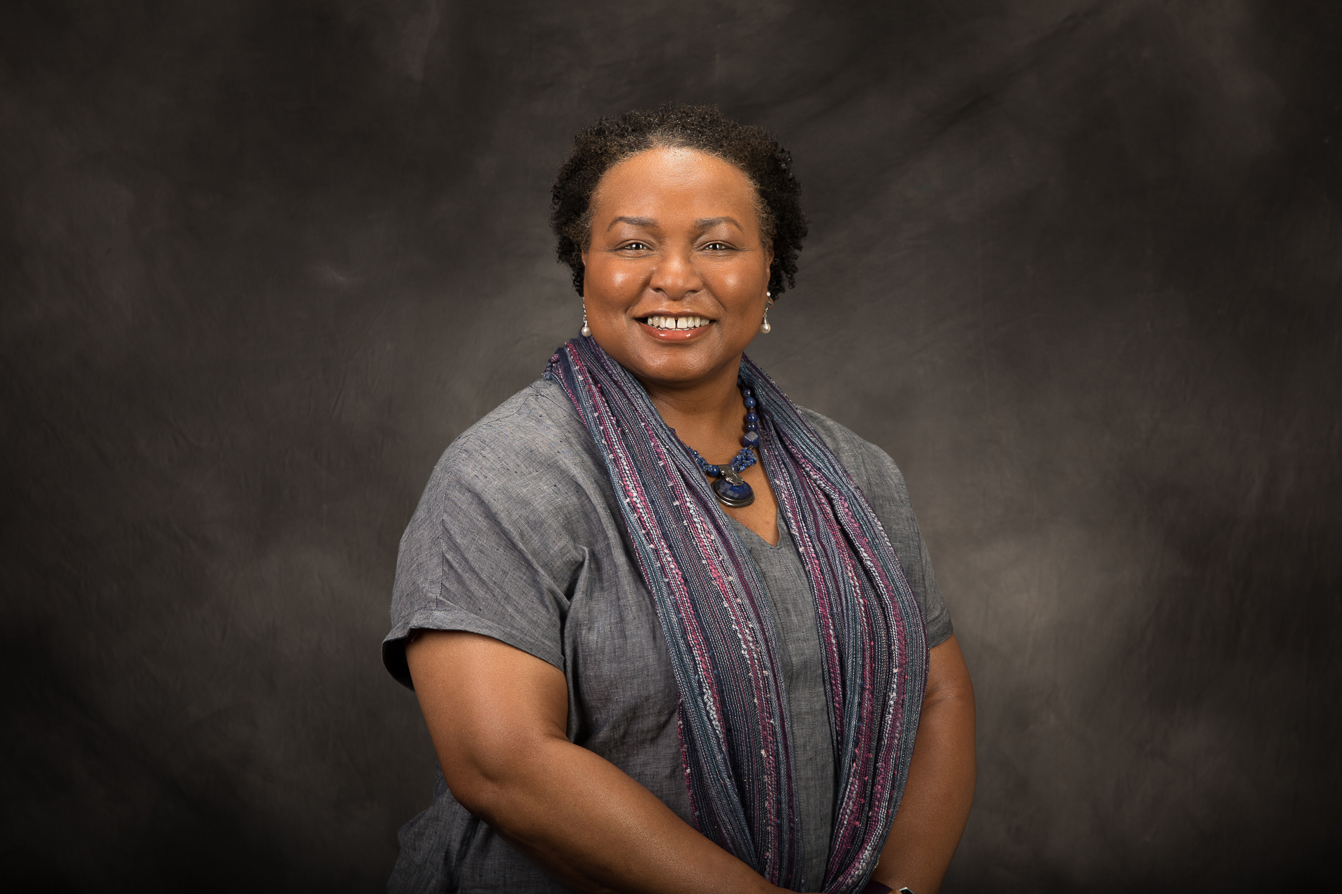 Sac State Associate Vice President for Research, Innovation, and Economic Development Yvonne Harris posing on a black and grey studio background. 