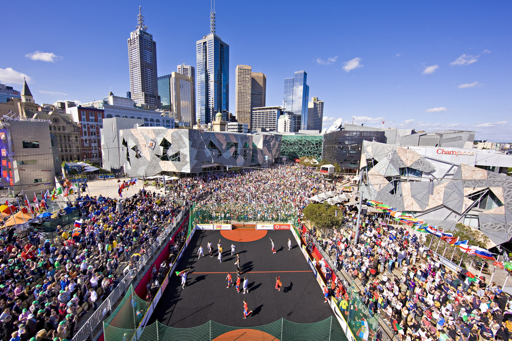 An overhead shot of the Homeless World Cup in Melbourne, Australia, shows players on the court and lots of fans in attendance.