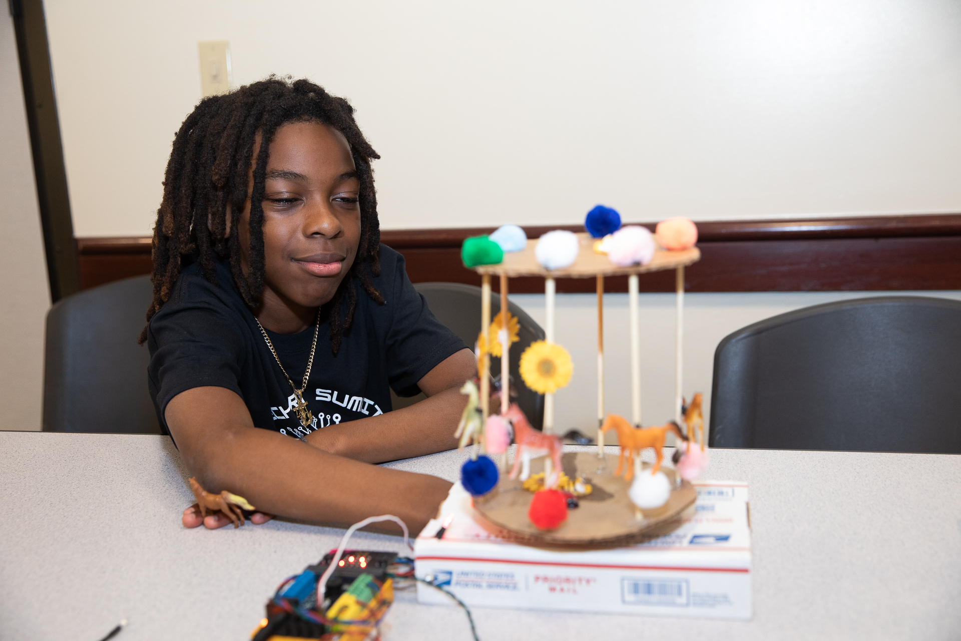 A sixth-grader admires his carousel project at the first Tech Art Summit at Sacramento State.