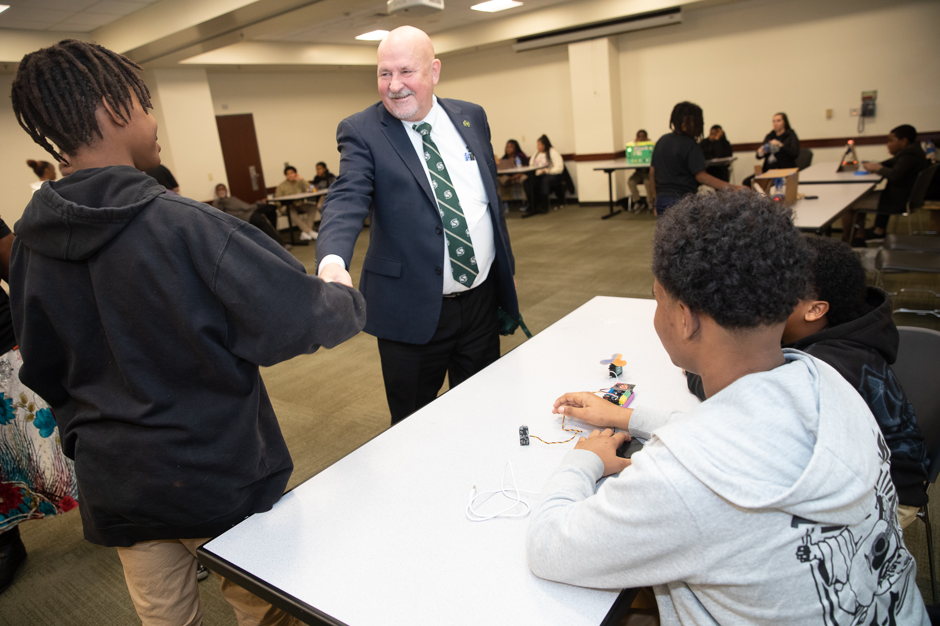 Sac State President Robert S. Nelsen greets middle school kids during the Tech Art Summit.