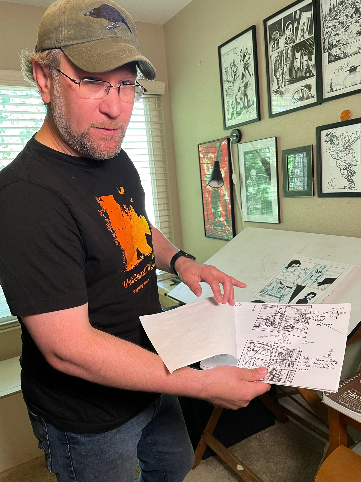 Sacramento State writing lecturer Dan Bethel shows off early versions of drawings for his comic book Long John in front of his drawing table at his home.