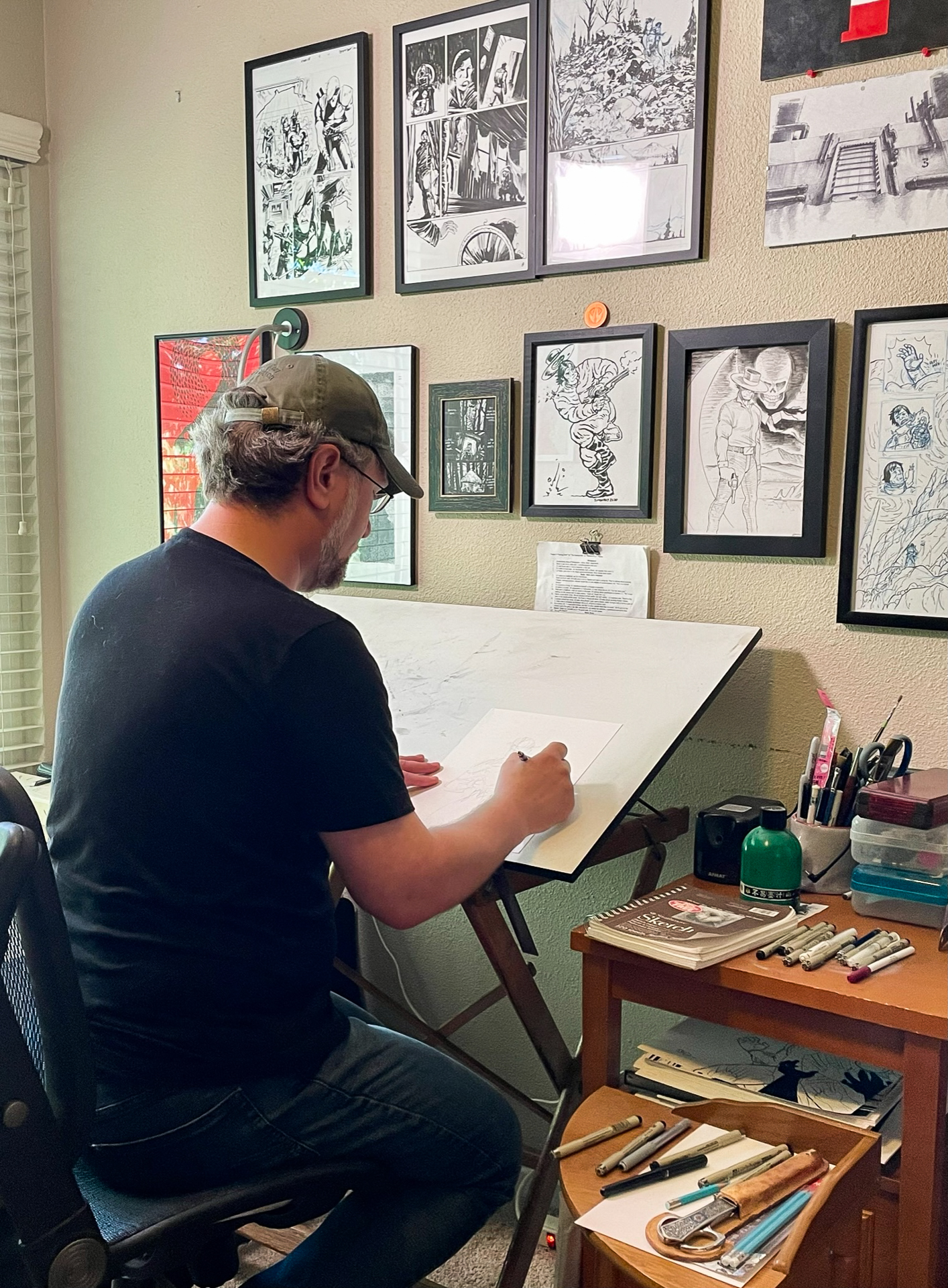 Dan Bethel, a writing lecturer at Sacramento State, sits at his art table in his home and works on drawings for his comic book Long John.
