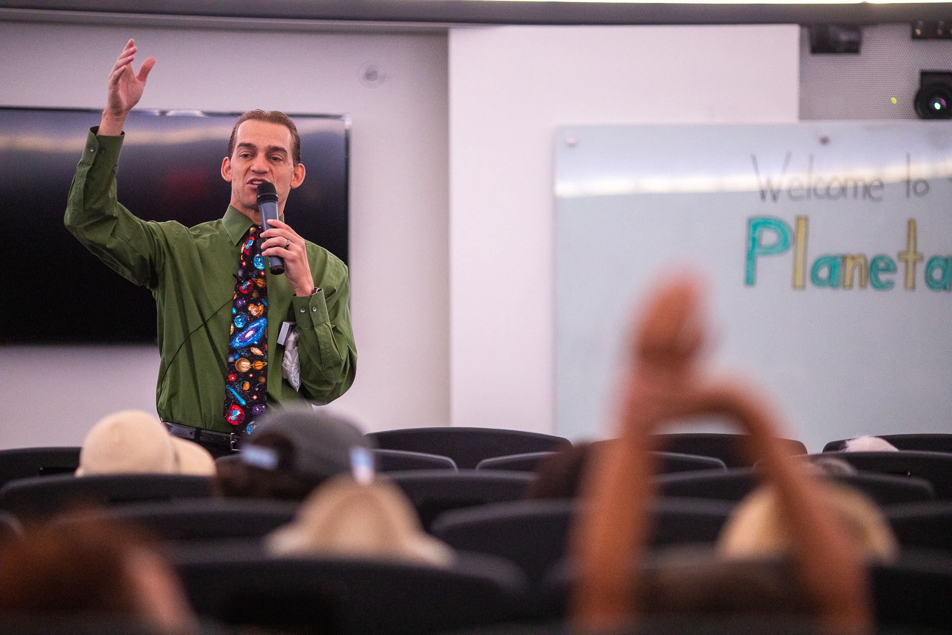 A speaker addresses a crowd at the Sac State Planetarium during an Open House event showing images from the James Webb Telescope.