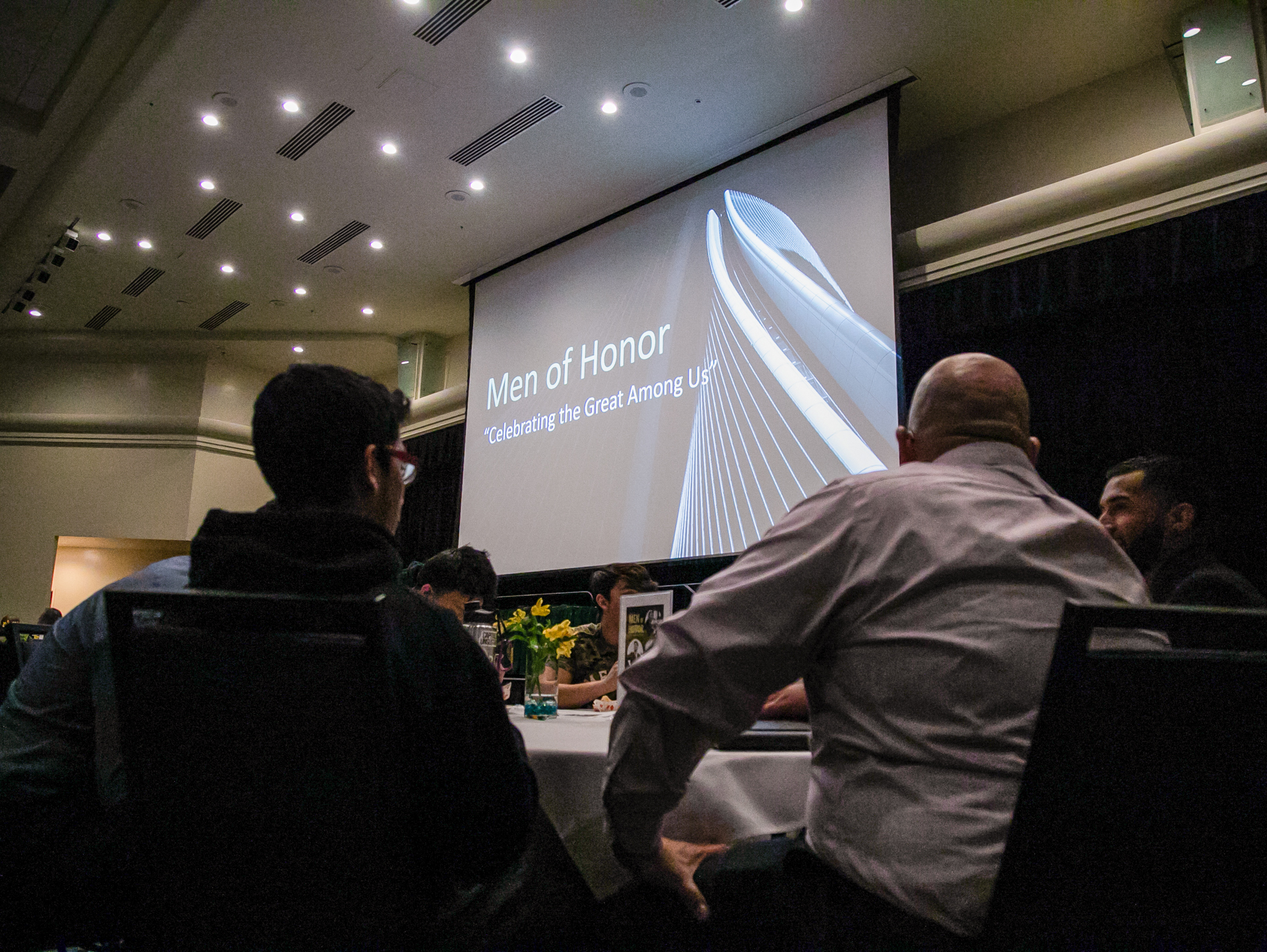 A group of faculty, staff, and community members sit at a table during a Male Empowerment presentation at Sacramento State. 