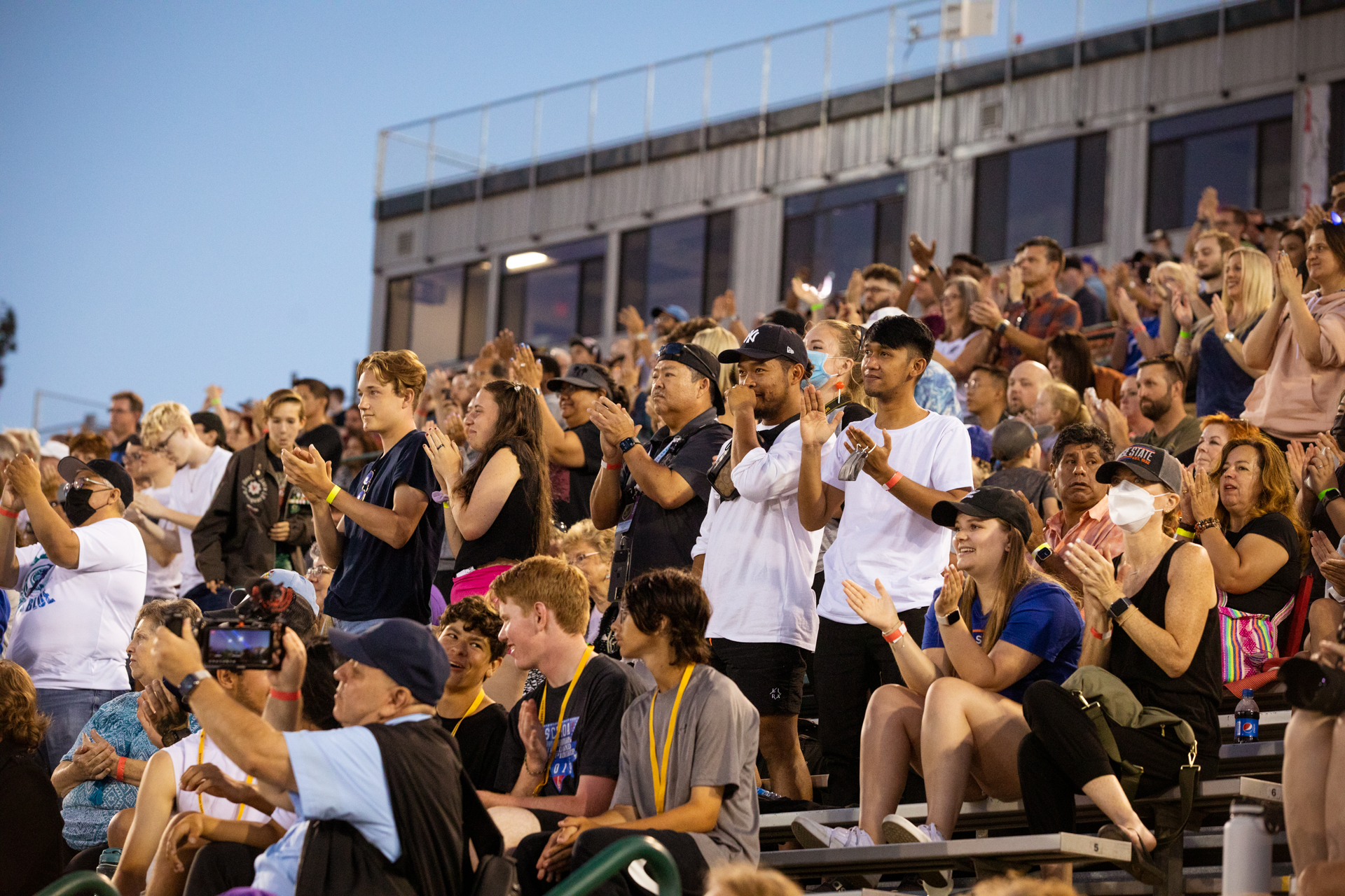 Fans in the stands at Sacramento State's Hornet Stadium cheer and applaud as the Sacramento Mandarins perform on the field.