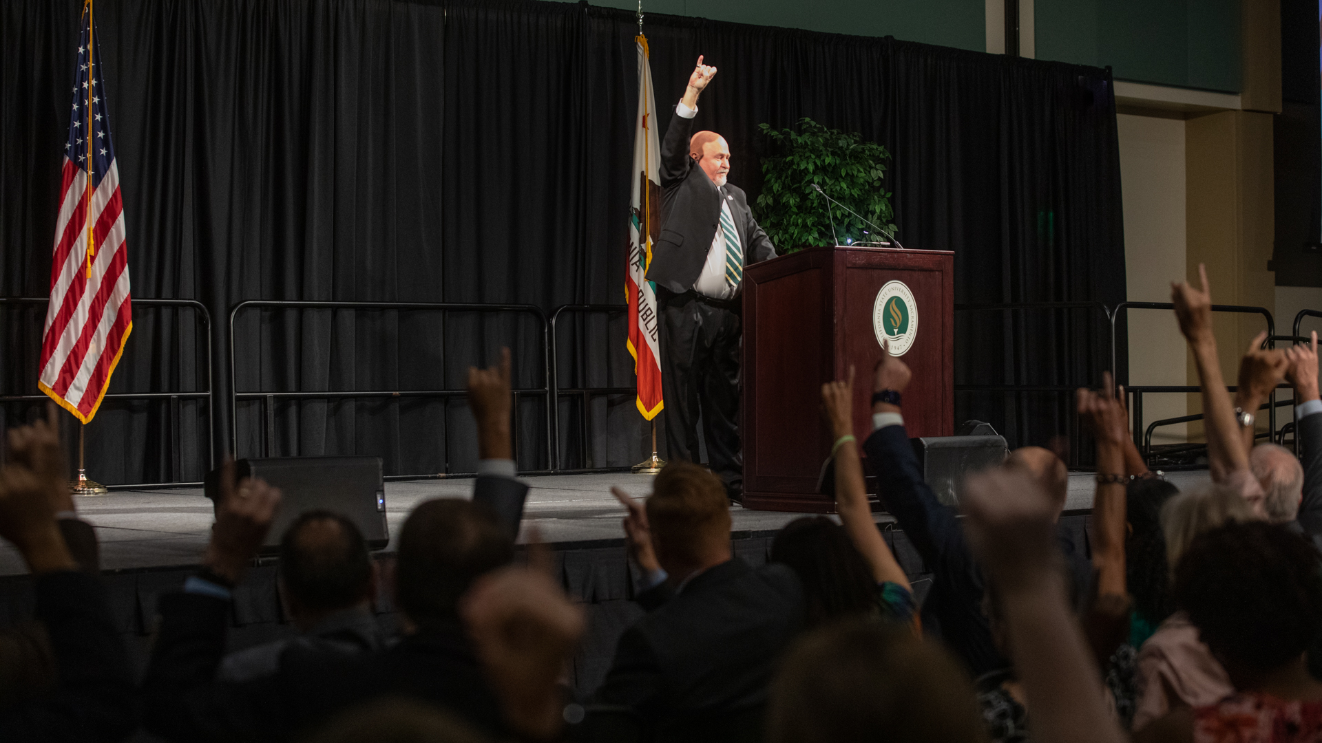 Sacramento State President Robert S. Nelsen salutes "Stingers Up" to the crowd as they salute back during the Fall Address. 