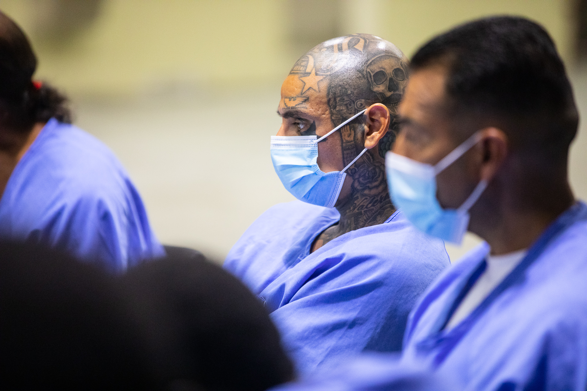 An inmate, who has tattoos on his face, at Folsom Prison sits in a circle of other inmates and participants in a restorative justice program workshop.