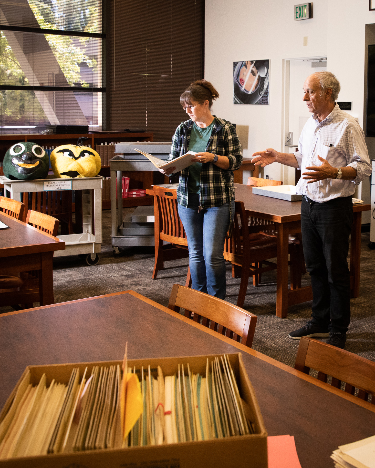 Archives staff members look through boxes of historical documents, photos, and objects for a Library exhibit.